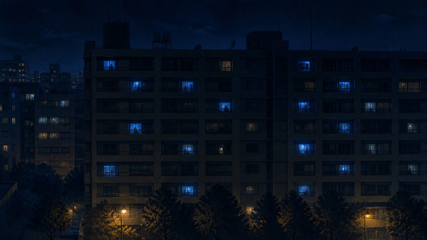 夜のマンション。多くの窓は暗いのに、いくつかの窓だけに青白い光が点っている